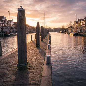 Palenrij langs kade in avondlicht