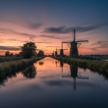 Rij molens bij Kinderdijk in de schemering
